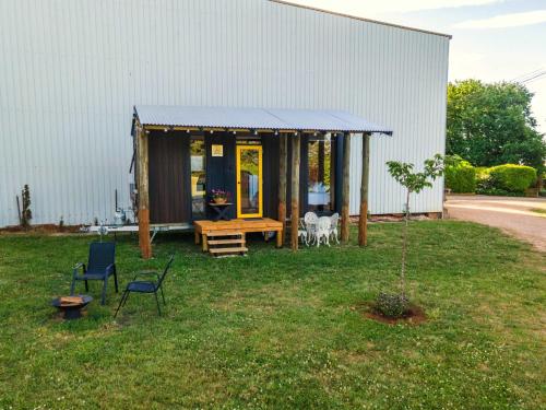 a small house with a blue roof in the yard at The Orchard View by Tiny Away in Nashdale