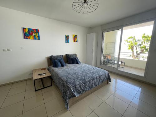 a bedroom with a bed and a large window at Studio Bellepierre, vue mer in Saint-Denis