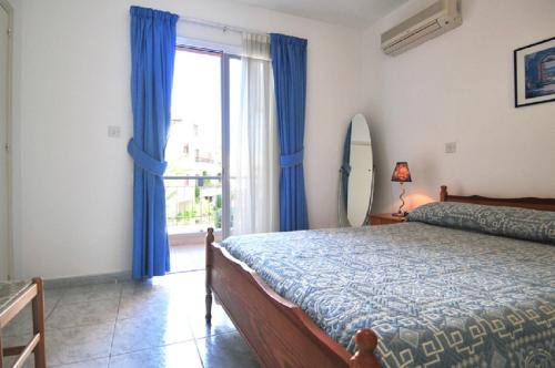 una camera con letto e finestra con tende blu di PAFIA suite a Paphos