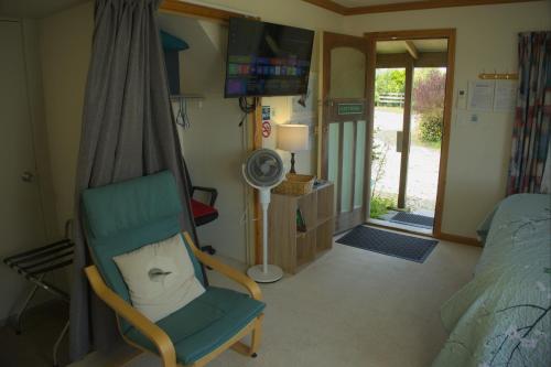 a bedroom with a chair and a bed and a window at Hilltop guest room, Escape the city! in Pukehiki