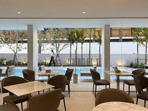 a restaurant with tables and chairs and a pool at POR Kotchasarn in Chiang Mai