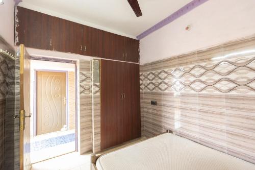 a bathroom with wooden walls and a window and a door at MAS Residency Home in Pudukkottai