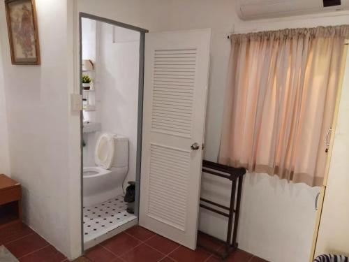 a bathroom with a white toilet and a mirror at Mountain View Garden House in Ban Chong Phli