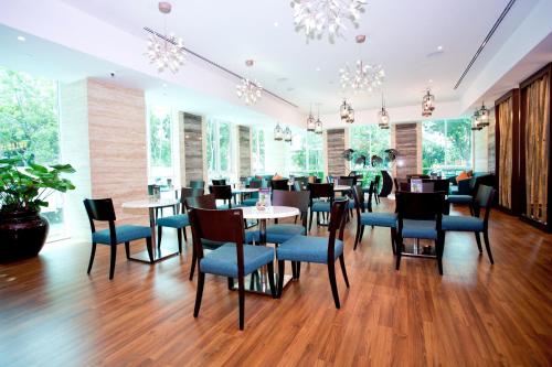 a restaurant with blue chairs and tables and windows at Vouk Hotel Suites, Penang in George Town