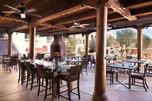 a restaurant with tables and chairs and a fireplace at Hyatt Regency Tamaya South Santa Fe in Santa Ana Pueblo