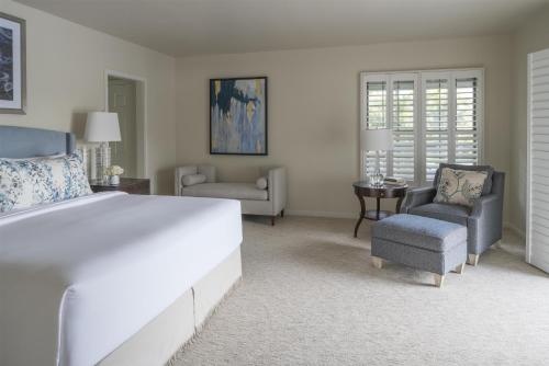 a bedroom with a large white bed and two chairs at Hyatt Regency Grand Cypress Resort - Free Shuttle to Theme Parks! in Orlando