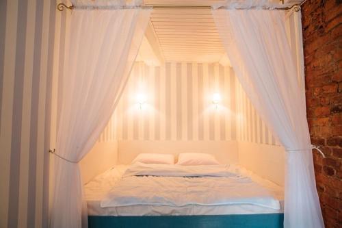 a bedroom with a canopy bed with white curtains at Studio on Morskaya 25 in Saint Petersburg