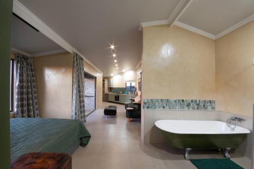 a bedroom with a bed and a bath tub and a bed sidx sidx at Fourfields Hogsback in Hogsback