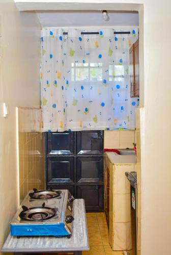 a kitchen with a stove top in a room at Cozy Homes in Thika