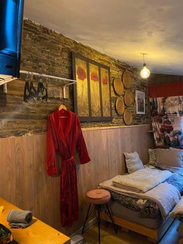 a room with a bed and a red robe hanging on a wall at My cosy space in Spa