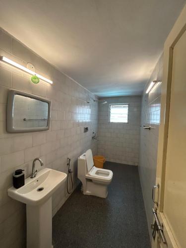 a bathroom with a white toilet and a sink at The golden villa in Calangute