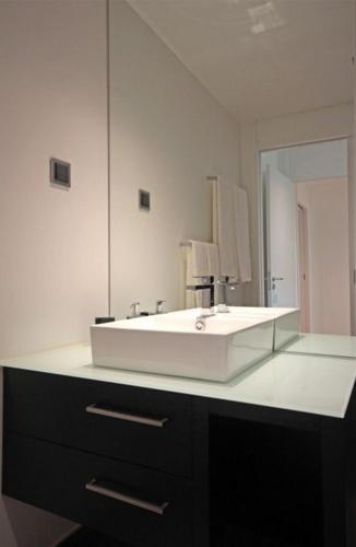 a bathroom with a white sink and a mirror at Astro Madeira Apartments in Funchal