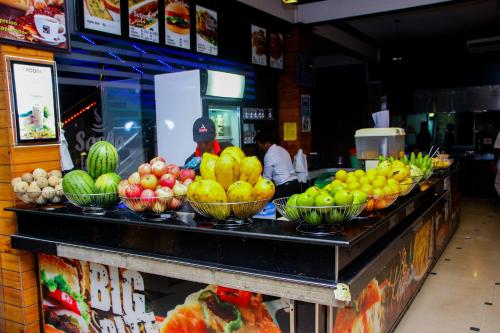 a counter with bowls of fruits and vegetables on it at Sasha Transit Hotel in Katunayake
