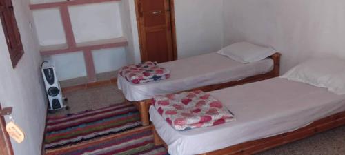 two twin beds in a room with a window at Forteresse Ait-Mezline in Timimoun