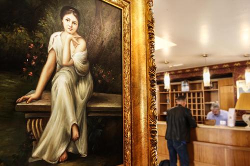 a painting of a woman sitting on a bench at Hotel Max in Aversa