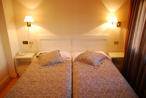 a bedroom with two beds with pillows on them at Hotel Iguareña in Ezcaray