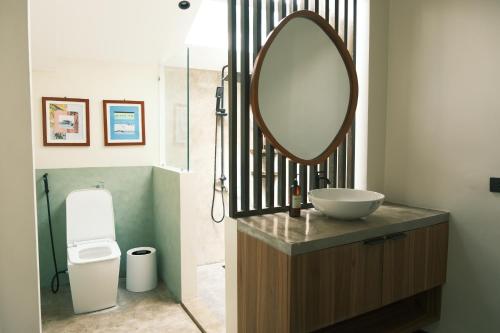 a bathroom with a sink and a mirror on a counter at Easy Does It Guesthouse Siargao in General Luna