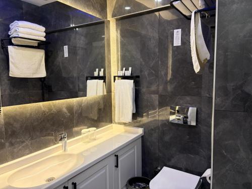 un baño con lavabo y espejo en Park Milano Hotel, en Izmir