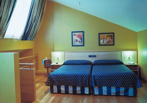 a bedroom with a bed with a blue and white comforter at Hotel Estrella Norte in Isla