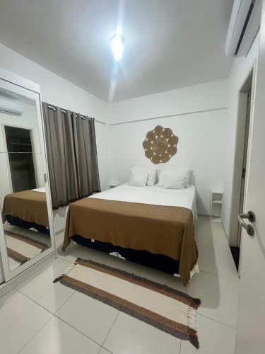 una camera da letto con un letto grande e uno specchio di Cumbuco Residencial Dunas Beach apt.203 a Cumbuco