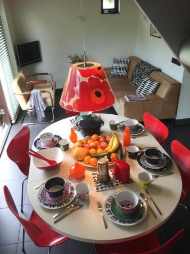 a table with a bunch of fruit on it at Bergen Holiday Home in Schoorl