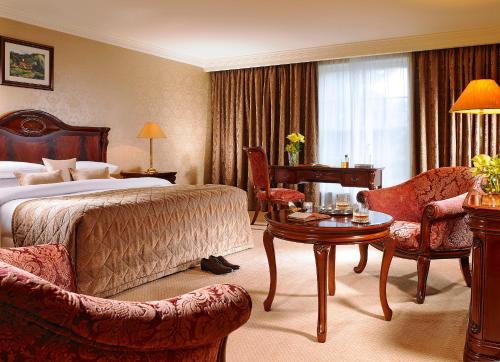 a hotel room with a bed and a table and chairs at Citywest Hotel in Citywest