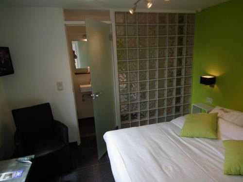 a bedroom with a white bed and a green wall at Holiday Home New Largo in Nieuwpoort