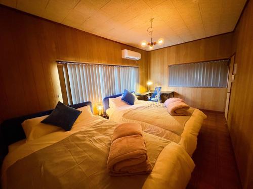 a bedroom with two beds with pillows on them at Casa Arita in Zōshuku