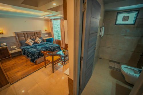 a bedroom with a bed and a bathroom with a toilet at Singhs BnB by Lazy Getaways in Shimla
