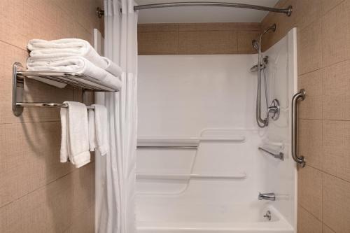 a bathroom with a shower and a sink and towels at Spark by Hilton Fishkill in Fishkill