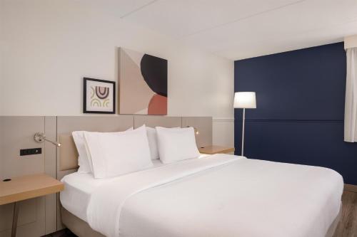 a large white bed in a hotel room at Spark by Hilton Fishkill in Fishkill
