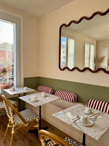 a dining room with two tables and a mirror at Hotel Saint Louis in Brest