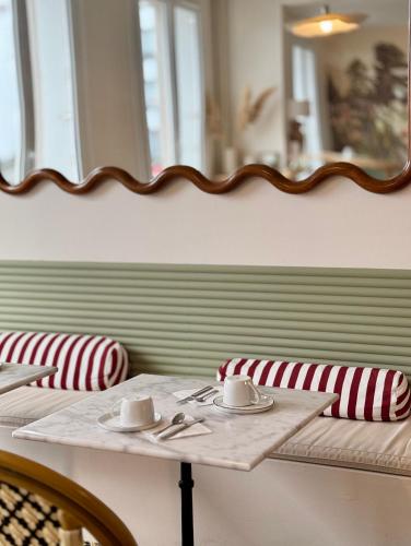 een tafel met twee stoelen en een spiegel aan de muur bij Hotel Saint Louis in Brest