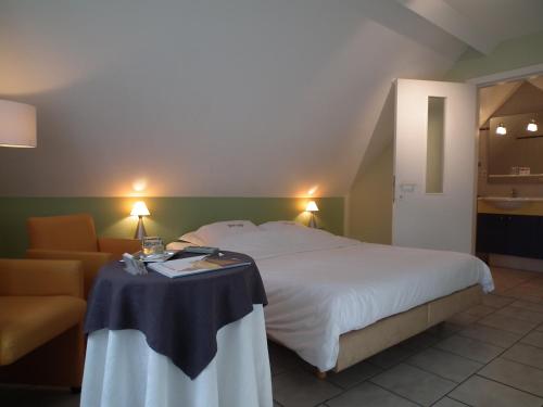 a bedroom with a bed and a table and a couch at Holiday Home New Largo in Nieuwpoort
