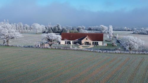 a large house with a field in front of it at Aux 3 Forêts in Bizeneuille