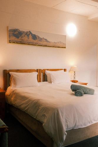 a bedroom with a large bed with white sheets and pillows at Sunrise Cottage in Wilderness