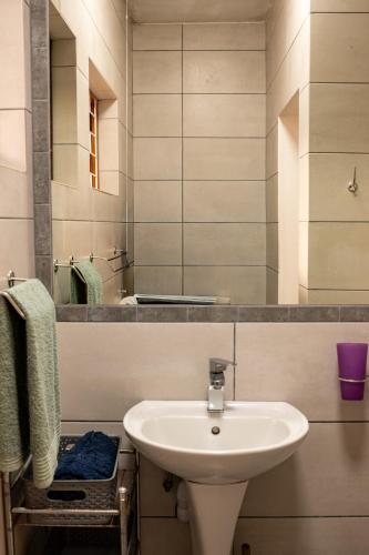 a bathroom with a white sink and a mirror at Sunrise Cottage in Wilderness