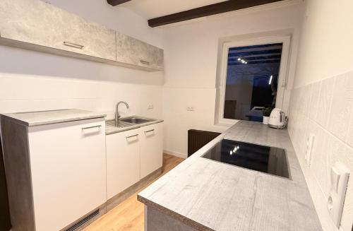 a kitchen with white cabinets and a sink and a window at HANOSAN Apartments Familienhaus 4 Zimmer 125 m2 in Garbsen