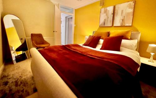 a bedroom with a large bed and a chair at Hollybush House in Welwyn Garden City