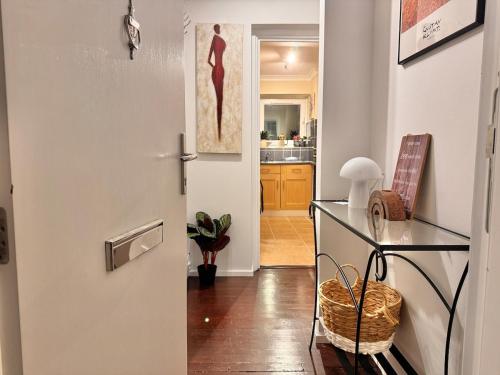 a room with a door and a table and a kitchen at Hollybush House in Welwyn Garden City