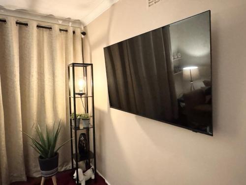 a large flat screen tv hanging on a wall at Hollybush House in Welwyn Garden City
