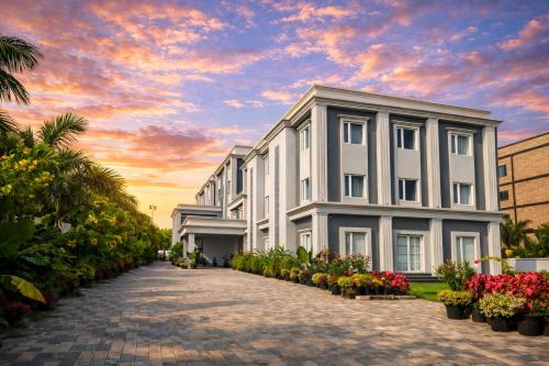a white building with flowers in front of it at La Franklin Hotel in Parādīp Garh