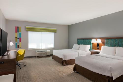 a hotel room with two beds and a desk and a television at Hampton Inn Lake Charles in Lake Charles