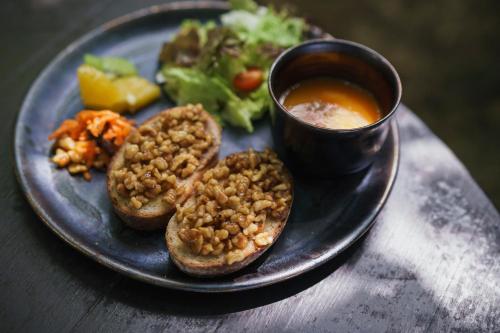 a plate of food with bread and a cup of soup at Villa UUJI-KAZE ヴィラ ウージ カゼ in Nanjo