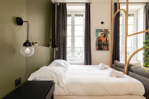a bedroom with a large white bed and a window at Cosy studio - 2P - Bellecour in Lyon