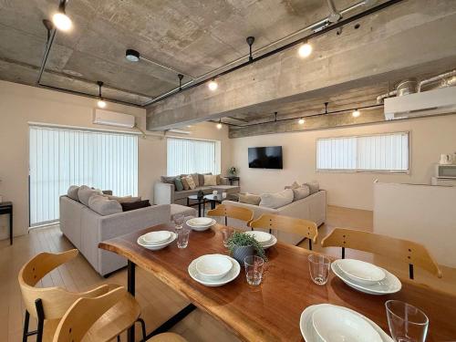 a dining room and living room with a table and chairs at b hotel M's lea - Beautiful Modern Apt City Center for 10Ppl in Hiroshima