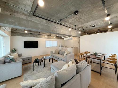 a large living room with couches and a flat screen tv at b hotel M's lea - Beautiful Modern Apt City Center for 10Ppl in Hiroshima
