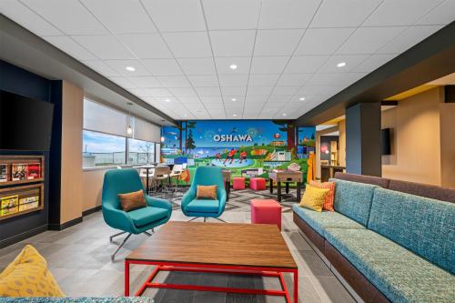 a waiting room with a couch and chairs and a table at Tru By Hilton Oshawa in Oshawa