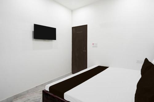a white room with a bed and a tv at Hotel O AB Rooms in Bareilly