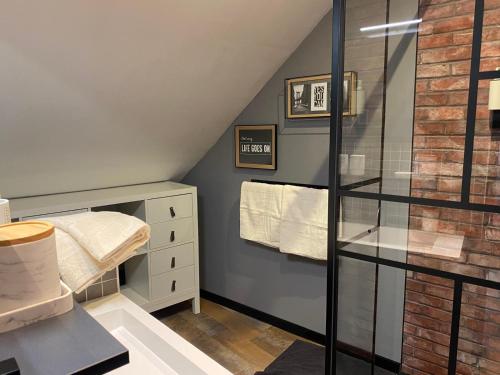a attic bathroom with a glass shower stall and towels at Les chambres du Bocage - Chambre Marylin in Bressuire